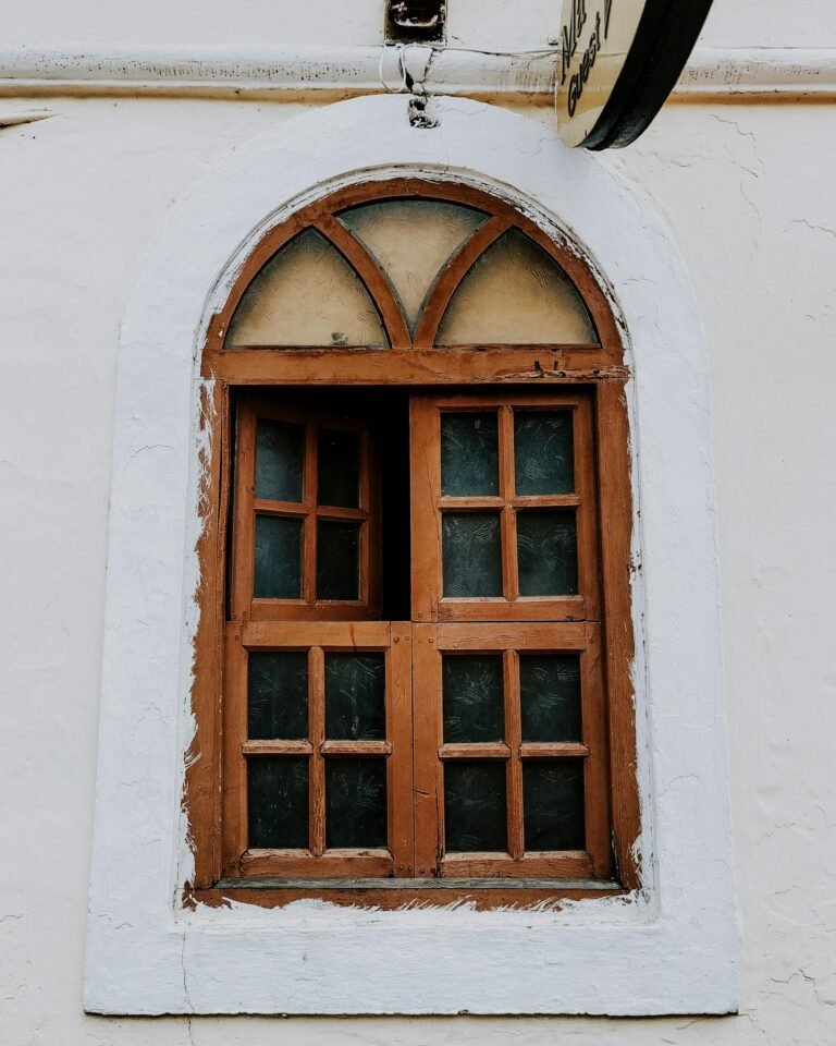 Photograph of an arched wooden window with intricate design in Gujrat, India.